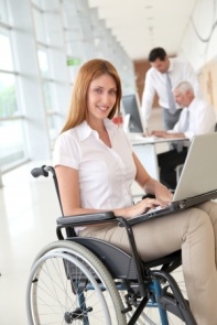 Lady in office, using a laptop, whilst using a wheelchair